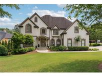 Beautiful two-story home with lush green lawn and meticulously manicured landscaping at 100 Pine Mist Cir, Alpharetta, GA 30022