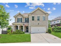 Charming two-story home with a well-manicured lawn, brick facade, and attached two-car garage at 4020 Huron Dr, Cumming, GA 30028