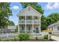 Charming two-story home featuring a double balcony, fresh landscaping, and a classic white picket fence at 683 Terry Se St, Atlanta, GA 30315