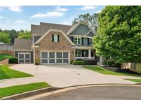 Charming two-story home features a brick and siding facade, three car garage and a beautifully landscaped front yard at 525 Wallis Farm Ln, Marietta, GA 30064