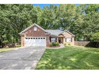 Charming brick home featuring a manicured lawn, two-car garage, and welcoming front entrance at 6788 Oakhurst Court Ct, Douglasville, GA 30134