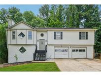 Split level home with attached garage, interesting window design, and front yard grass at 185 Hickory View Dr, Lawrenceville, GA 30046