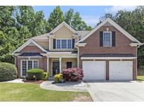 Charming two-story brick and siding home with a manicured front yard and two-car garage at 1611 Hillside Bend Xing, Lawrenceville, GA 30043