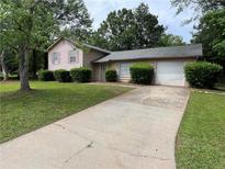 Charming single-story home featuring a two-car garage and a well-maintained front yard with mature trees at 3429 Timbercreek Dr, Lawrenceville, GA 30044