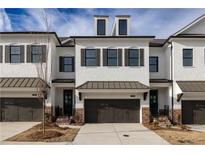 New construction townhome with a brick foundation, two-car garage, and neutral white paint at 816 Dodd S Trl # 172, Buford, GA 30518