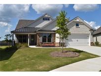 Charming home with stone accents, a manicured lawn, and a welcoming front porch at 1619 Tielman Way, Snellville, GA 30078