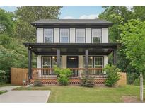 Charming two-story home featuring a covered front porch with black accents and well-maintained landscaping at 1158 Welch Sw St, Atlanta, GA 30310