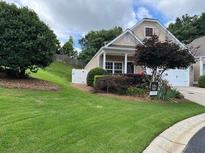 Well-maintained home with a lush, green lawn, and tidy landscaping at 407 Aerif Pl, Woodstock, GA 30188