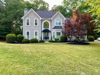 Charming two-story home with a well-manicured lawn, mature trees, and impeccable landscaping at 1801 Summerview Ct, Woodstock, GA 30189