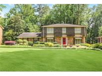 Charming two-story home with a well-manicured lawn and lush landscaping at 850 John Alden Rd, Stone Mountain, GA 30083