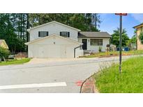 Two-story home featuring an attached two car garage and neutral paint at 3735 Benchmark Dr, Atlanta, GA 30349