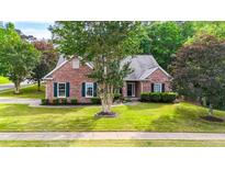 Charming brick home featuring a well-manicured lawn and established trees at 507 Huntgate Rd, Woodstock, GA 30189