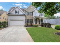 Charming home with a well-manicured lawn, beautiful landscaping, and a two-car garage at 3980 Suwanee Place Dr, Suwanee, GA 30024