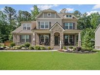 Charming two-story home with a manicured lawn, stone accents, and a welcoming front porch at 4960 Norman Ct, Cumming, GA 30040