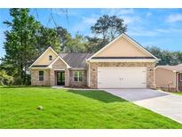 Charming brick home with a well-manicured lawn, attached garage, and welcoming entryway at 8544 Plumtree Dr, Riverdale, GA 30274