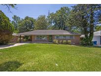 Charming brick ranch-style home featuring a well-maintained lawn and complemented by lush, mature trees at 2261 Star Mist Sw Dr, Atlanta, GA 30311