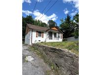 Charming home with painted brick, a cozy porch, and a stone retaining wall at 303 Anderson Nw Ave, Atlanta, GA 30314