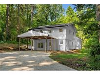 Charming two-story home with a covered carport surrounded by lush greenery at 2984 E Paulding Dr, Dallas, GA 30157