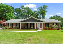 Charming brick ranch-style home with a well-manicured lawn and inviting covered porch at 8415 Ridge Rd, Fairburn, GA 30213