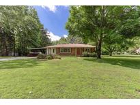 Ranch-style home with mature trees and a covered carport on a spacious lot at 4545 Gaydon Rd, Powder Springs, GA 30127