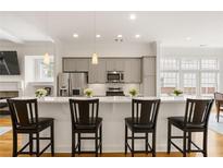 Bright eat-in kitchen features stainless steel appliances, gray cabinets, pendant lights, and countertop dining at 1258 Dekalb Ne Ave # 112, Atlanta, GA 30307