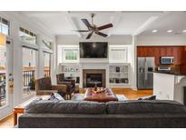 Bright living room featuring a fireplace, built-in shelving, ceiling fan and access to a balcony at 1258 Dekalb Ne Ave # 112, Atlanta, GA 30307