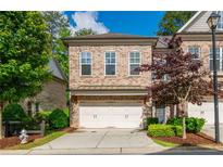 Charming two-story brick townhome with a two-car garage and manicured landscaping in a desirable neighborhood at 2021 Towneship Trl, Roswell, GA 30075
