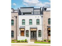 Charming townhome with a white painted brick exterior and a rooftop deck, perfect for city living at 338 Sugarview Rd, Sugar Hill, GA 30518