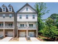 Charming townhouse with white siding, stone accents, and a welcoming covered porch perfect for enjoying the outdoors at 2106 Remy Ct, Kennesaw, GA 30144