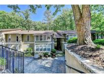 Inviting exterior view of a multi-story townhome surrounded by mature trees at 5149 Roswell Rd # 7, Atlanta, GA 30342