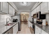 Galley kitchen features granite countertops and stainless steel appliances at 5149 Roswell Rd # 7, Atlanta, GA 30342
