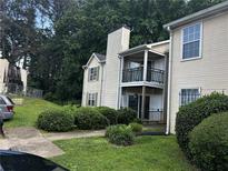 Beige two-story condo with black balcony railing and manicured front lawn at 621 Ridge Creek Dr, Clarkston, GA 30021