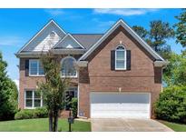 Charming two-story brick home featuring a well-manicured lawn and attached two-car garage at 3400 Dencrest Se Ct, Smyrna, GA 30080