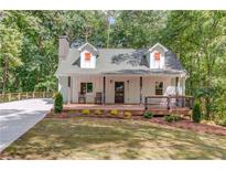 Charming cottage-style home with a welcoming front porch and well-manicured lawn at 5345 Pilgrim Point Rd, Cumming, GA 30041