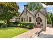Charming home featuring a stone chimney, brick walkway, and well-manicured landscaping at 1748 N Pelham Ne Rd, Atlanta, GA 30324