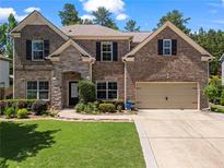 Charming two-story brick home featuring a well-manicured lawn and an attached two-car garage at 237 Parc Drive Dr, Canton, GA 30114