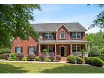 Traditional brick home with a covered front porch and manicured landscaping at 140 Melrose Creek Dr, Stockbridge, GA 30281