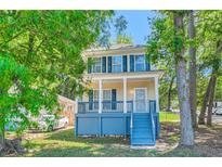 Charming two-story home featuring a inviting front porch with blue accents and lush landscaping at 1331 Memorial Se Dr, Atlanta, GA 30317