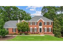 Charming two-story red brick home features black shutters, arched entry, and well-manicured lawn at 1206 Mountainside Nw Trce, Kennesaw, GA 30152