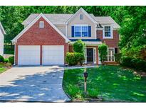 Charming two-story brick home with manicured lawn and attached two-car garage at 136 Parkstone Way, Marietta, GA 30066