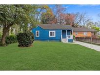 Charming blue home featuring a well-maintained lawn and inviting front porch at 5074 Park Ave, Forest Park, GA 30297