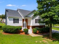 Charming two-story home features a manicured lawn, complemented by a white exterior, and a welcoming front porch with a brick accent at 5077 Fieldview Dr, Douglasville, GA 30135