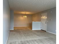 Open living area with neutral carpet, lighting fixture and convenient front door access at 17301 Waldrop Cv, Decatur, GA 30034