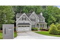 Beautiful two-story home featuring a two-car garage, gray siding, and professionally landscaped front yard at 2585 Drew Valley Ne Rd, Brookhaven, GA 30319