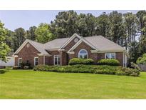 Beautiful brick home featuring lush landscaping, a manicured lawn, and a classic architectural design at 3845 Glen Ian Dr, Loganville, GA 30052