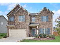 Charming two-story brick home features a two-car garage, manicured lawn, and inviting curb appeal at 1173 Gaines St, Jonesboro, GA 30238