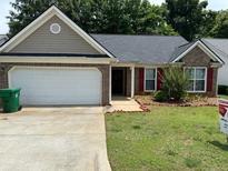 Charming single-story home featuring a two-car garage, brick accents, and a well-maintained lawn at 2863 Hillvale Cove Dr, Lithonia, GA 30058