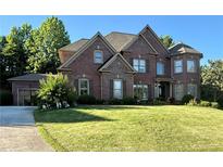 Charming two-story brick home with manicured lawn, mature trees, and an attached two-car garage at 3332 Heathchase Ln, Suwanee, GA 30024