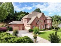 Stunning two-story brick home with a meticulously maintained lawn and three-car garage at 3332 Heathchase Ln, Suwanee, GA 30024