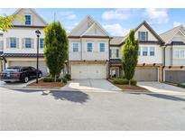 Charming townhome with a two-car garage and well-maintained landscaping, perfect for suburban living at 1241 Hightower Nw Xing, Marietta, GA 30060